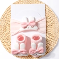 Detail of pink knitted baby headband and socks set featuring cute white rabbit dolls - Light Pink