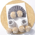 Détail d'un ensemble bonnet turban et chaussettes bébé avec nœuds brodés sur présentoir - Ensemble Bonnet et Chaussettes / Gris