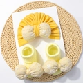 Détail de l'ensemble bonnet et chaussettes bébé jaune avec nœuds brodés de fleurs - Ensemble Bonnet et Chaussettes / Jaune