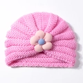 Detail der rosa gestrickten Baby-Turbanmütze mit 3D-gestreifter Blume und blauem Kern - Rosa