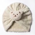 Detailed view of plush cream baby hat featuring a soft pink bear embroidery decoration - Beige