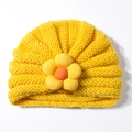 Dettaglio del cappello in maglia gialla per neonati con un fiore di girasole 3D - Giallo ocra