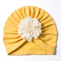 Dettaglio del turbante giallo per neonati con un grande fiore decorativo in tessuto bianco - Giallo