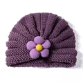 Dettaglio della texture del cappello in maglia viola scuro per neonati con fiore - viola taro