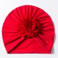 Dettaglio di un cappello a turbante rosso per neonati con grande fiore e trama pieghettata - Rosso