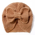 Detailed knit texture of ginger baby beanie featuring a large decorative bow - Coffee