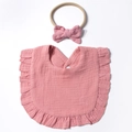 Detail view of pink cotton muslin baby bib with ruffles and matching bow headband - Dust Rose