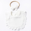 Dettaglio del set bavaglino e fascia per neonati con balze e trama in puro cotone - Bianco