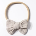 Close-up of beige nylon baby headband featuring double-layered linen bow texture - Gray