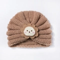 Détail d'un bonnet turban en tricot marron pour bébé avec un joli écusson de lion - Café