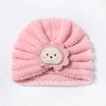 Close-up of pink knit baby hat with soft ribbed texture and cute lion embroidery patch - Nude Pink