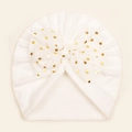 Detail of white baby turban featuring golden polka dot bow and soft fleece lining - White