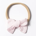 Detail of light pink soft muslin cotton bow on stretchable nude nylon baby headband - Light Pink
