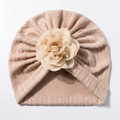 Détail du bonnet turban pour bébé en tricot beige avec une grande décoration florale - Café
