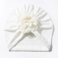 Detailed view of white baby turban beanie featuring a large decorative fabric flower - White