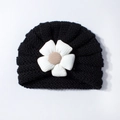 Close-up of black baby knit turban hat featuring a large 3D white fabric flower detail - Black