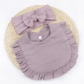 Detailed close-up of mauve cotton muslin baby bib with ruffles and a matching bow headband - Taro Purple