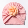 Pink cable knit baby turban hat with a large orange floral decoration on plain background - Nude Pink