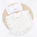 Detailed view of soft cotton muslin baby bib with ruffled edges and matching bow headband - White