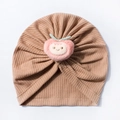 Close-up of waffle knit infant turban hat featuring a 3D plush peach decoration - Coffee