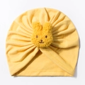 Detail of yellow baby turban hat with a plush rabbit head and soft pleated cotton texture - Yellow
