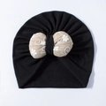 Detail of baby turban hat with a beige bow featuring floral embroidery and vine patterns - Black