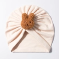 Close-up of baby turban hat featuring a soft teddy bear plush ornament and cotton fabric - Beige