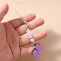 Detail of purple paw-shaped phone charm with star beads and enamel foot pendants - Purple
