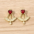 Detailed view of Cupid's arrow pendants with red heart stones on wood background - 5 Pieces / Gold Red