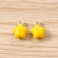 Vista macro di ciondoli a stella giallo brillante con anelli pendenti in metallo dorato - Giallo