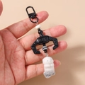 Close-up of mechanical claw plush keychain charm with soft faux fur animal detail - Black Otter