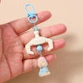 Detail of plush puppy keychain with blue plastic hook and colorful beads held in hand - Blue Dog