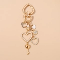 Detailed close-up of golden heart-shaped keychain with LOVE YOU tag and pearl charms - Heart With Key Keychain