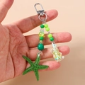 Detail of green resin starfish and milk tea cup pendant keychain with silver swivel clasp - Starfish Beaded Bear