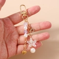 Dettaglio portachiavi a tema oceano con perle, perla viola e ciondolo a stella marina - Perla Cuore Stella Marina (Oro)