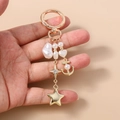 Dettaglio portachiavi dorato con perle, ciondolo a stella ed elemento ancora nautica - Stella di Perla