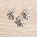 Close-up of three silver clown pendants for DIY jewelry making on a wooden background - Silver Clown