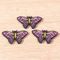 Macro view of colorful painted wooden butterfly charms for DIY jewelry and crafts - 10 Pieces Pack / Purple