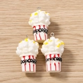 Detailed view of three 3D popcorn bucket charms with metal loops on a wood surface - 5 Pieces / Red