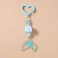 Detailed view of sea-inspired keychain with blue heart ring, fish tail, and glitter star - Fishtail Design / Light Blue