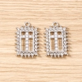 Macro shot of silver plated rectangular pendants with pearl cross and rhinestone frame - Silver Pearl