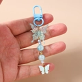 Detail eines Perlen-Schmetterlings-Schlüsselanhängers mit blauen Perlen und Karabiner - Himmelblau