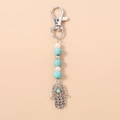 Detailed view of Hamsa Hand keychain with turquoise beads and silver lobster clasp - Turquoise Hamsa