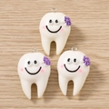 Tre simpatici ciondoli a forma di dente con fiori viola su sfondo in legno - 5 Pezzi / Viola