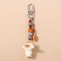 Detail of beaded keychain with cute white cat holding fish and mini croissant charms - Cat