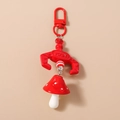 Close-up of cute red mushroom keychain with white dots and metallic D-ring hook - Red