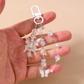 Detail of beaded butterfly keychain with aurora effect pendants and white lobster clasp - White