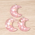 Detailed macro view of three crescent moon resin pendants with pink glitter and white stars - 10 Pieces Pack / Pink