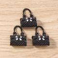 Close-up of black quilted handbag charms with white bows and woven handles for jewelry making - 5 Pieces / Black