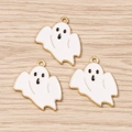 Détail de trois pendentifs fantômes en émail blanc avec bords dorés sur fond de bois - Lot de 10 / Or Blanc